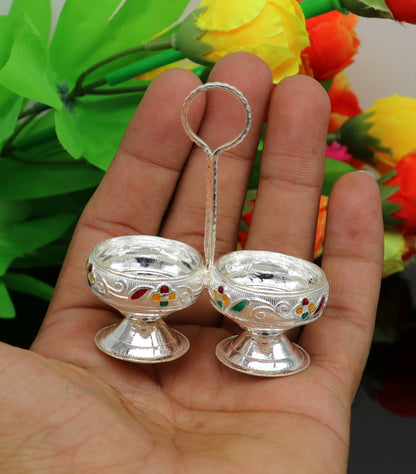 Handmade 925 sterling silver puja utensils including a silver tilak bowl and kumkum patra with intricate tribal design.