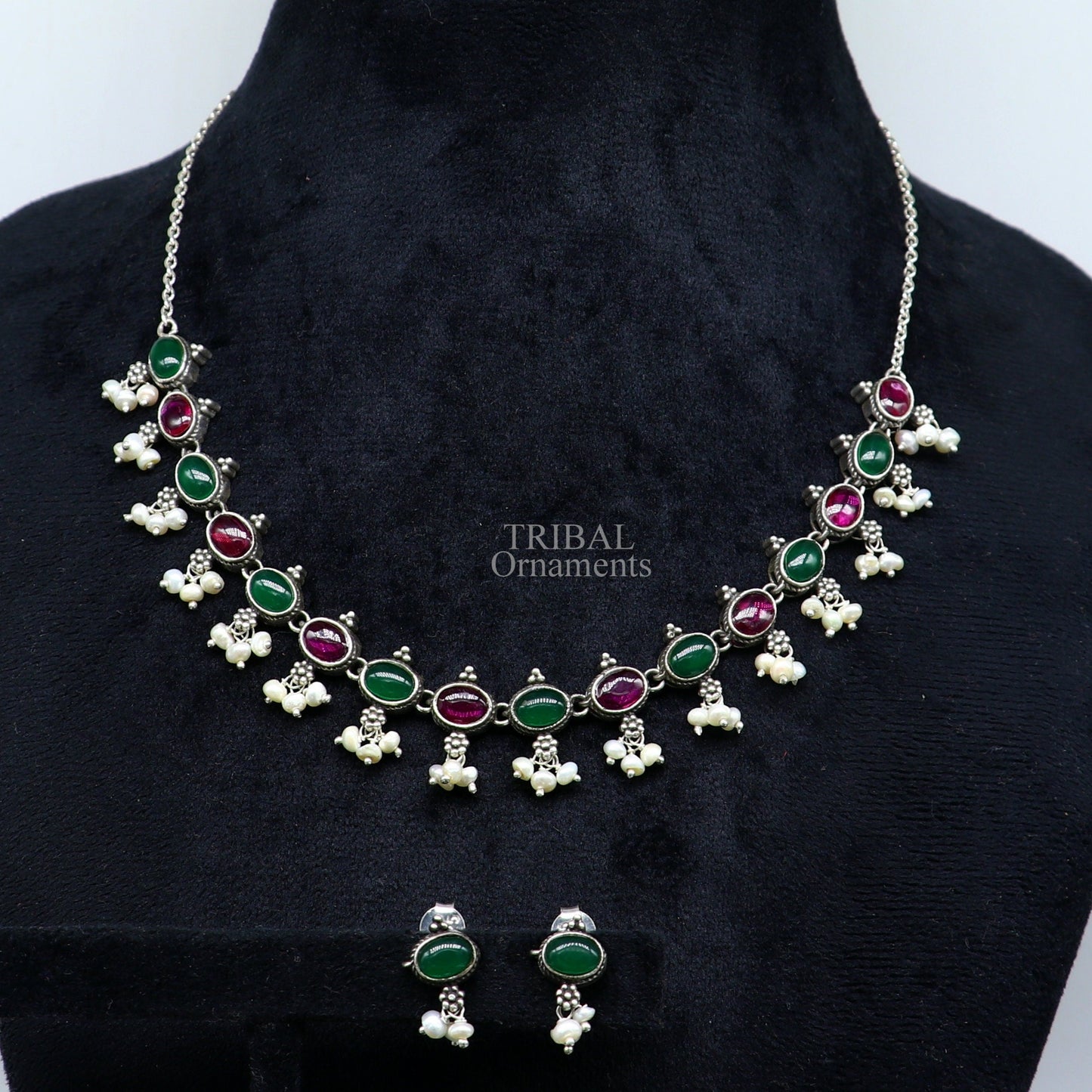 Sterling silver necklace with red and green stones, pearls, and intricate tribal design for wedding or special occasions.