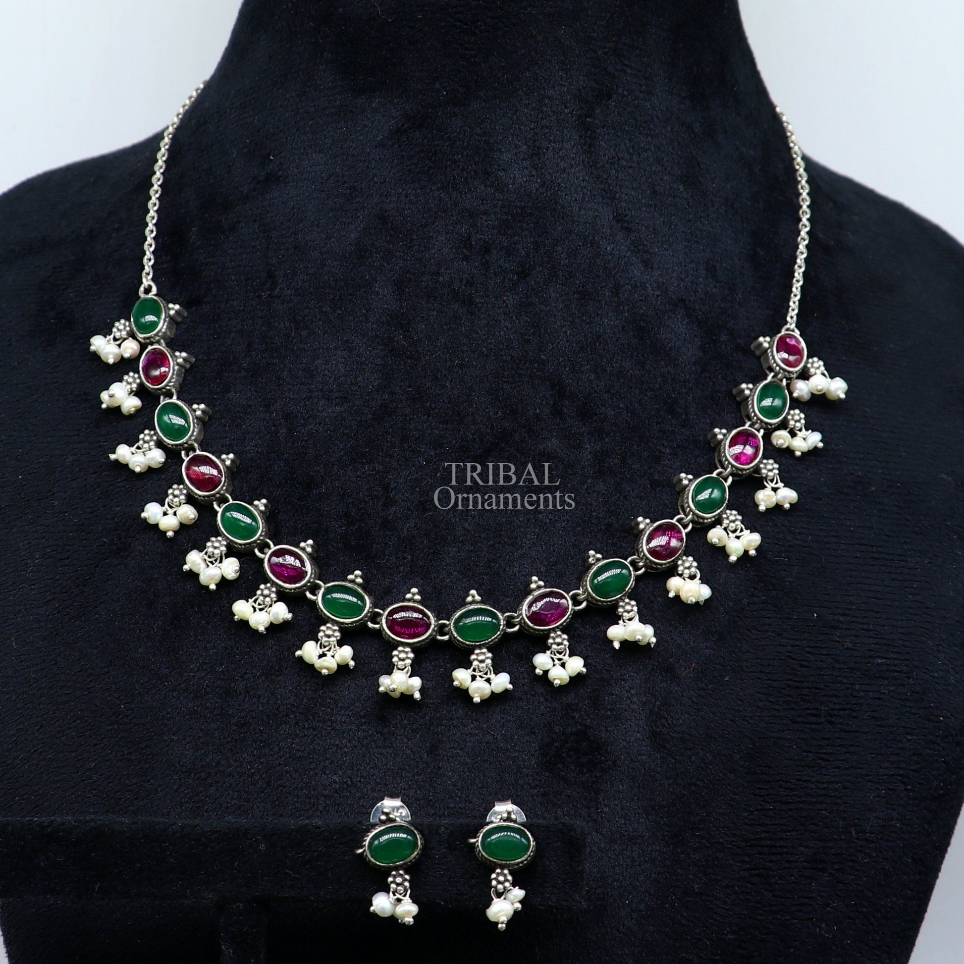 Sterling silver necklace with red and green stones, pearls, and intricate tribal design for wedding or special occasions.