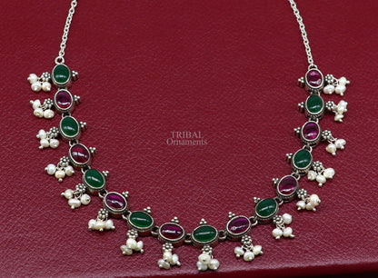 Sterling silver necklace with red and green stones, pearls, and intricate tribal design for wedding or bridal jewelry.