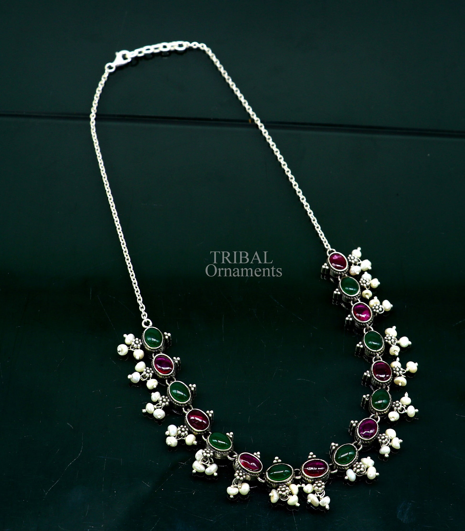 Sterling silver necklace with red and green stones, pearls, and intricate tribal design, perfect for wedding or bridal jewelry.