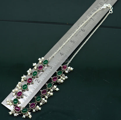 Sterling silver necklace with red and green stones, pearls, and charm, designed for weddings and special occasions.