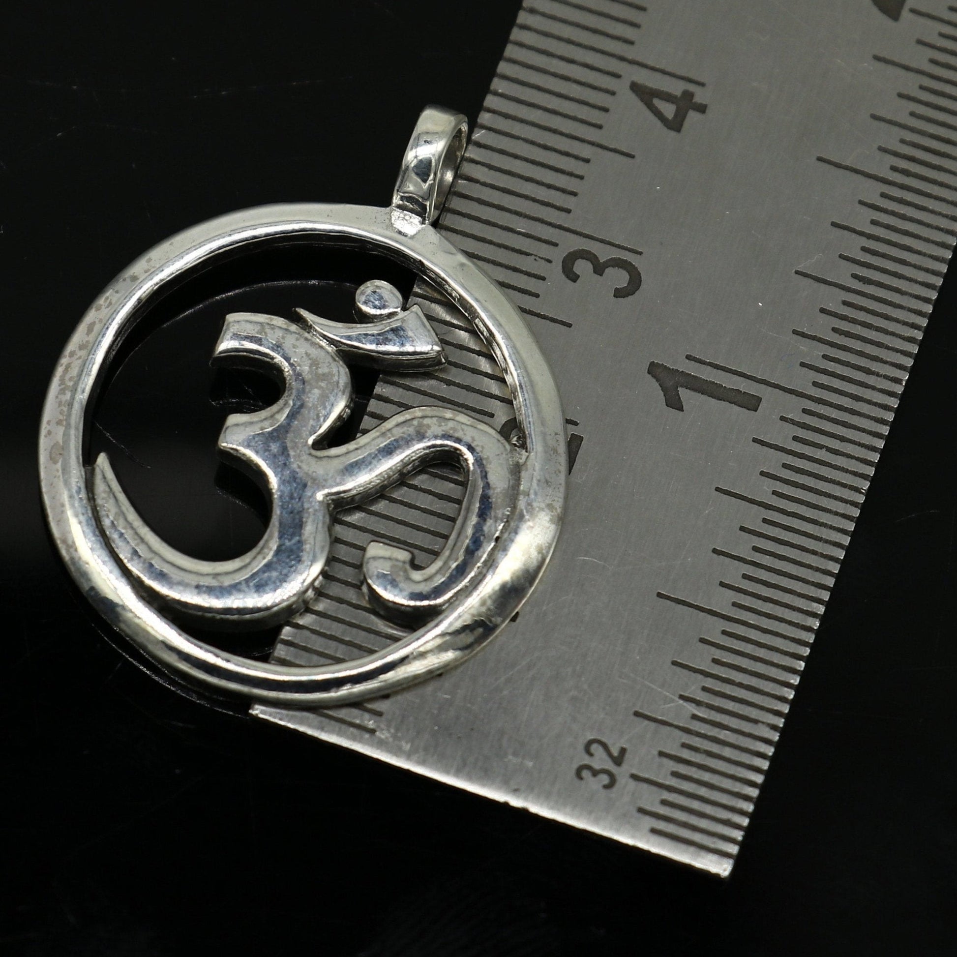 Sterling silver Hindu mantra 'Aum' OM pendant, unisex jewelry by TRIBAL ORNAMENTS, featuring intricate tribal design and handcrafted detail.