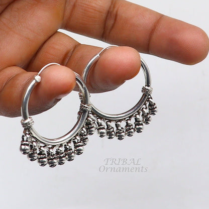 Sterling silver handmade hoop earring with hanging bells and hook design, showcasing tribal elegance and intricate craftsmanship.