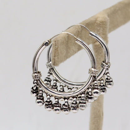 Elegant 925 sterling silver handmade hoop earring with hanging bells and hook design, featuring tribal-inspired details.