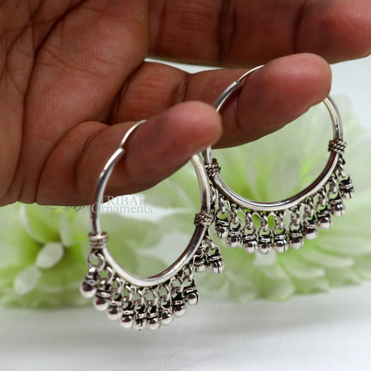 Sterling silver handmade hoop earring with hanging Bali bells, hook design, tribal-inspired jewelry by TRIBAL ORNAMENTS.