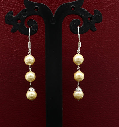 Sterling silver handmade hoop earrings with dangling pearls, perfect as bridesmaid jewelry or elegant drop earrings.