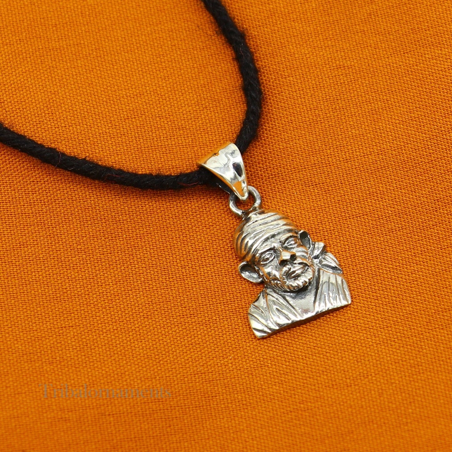 Sterling silver Sai Baba pendant by TRIBAL ORNAMENTS, handmade unisex jewelry featuring a detailed Indian deity design.