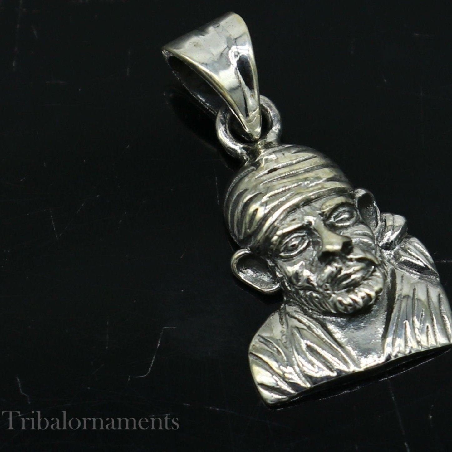 Sterling silver Sai Baba pendant by TRIBAL ORNAMENTS, unisex handmade jewelry featuring a detailed Indian deity design.