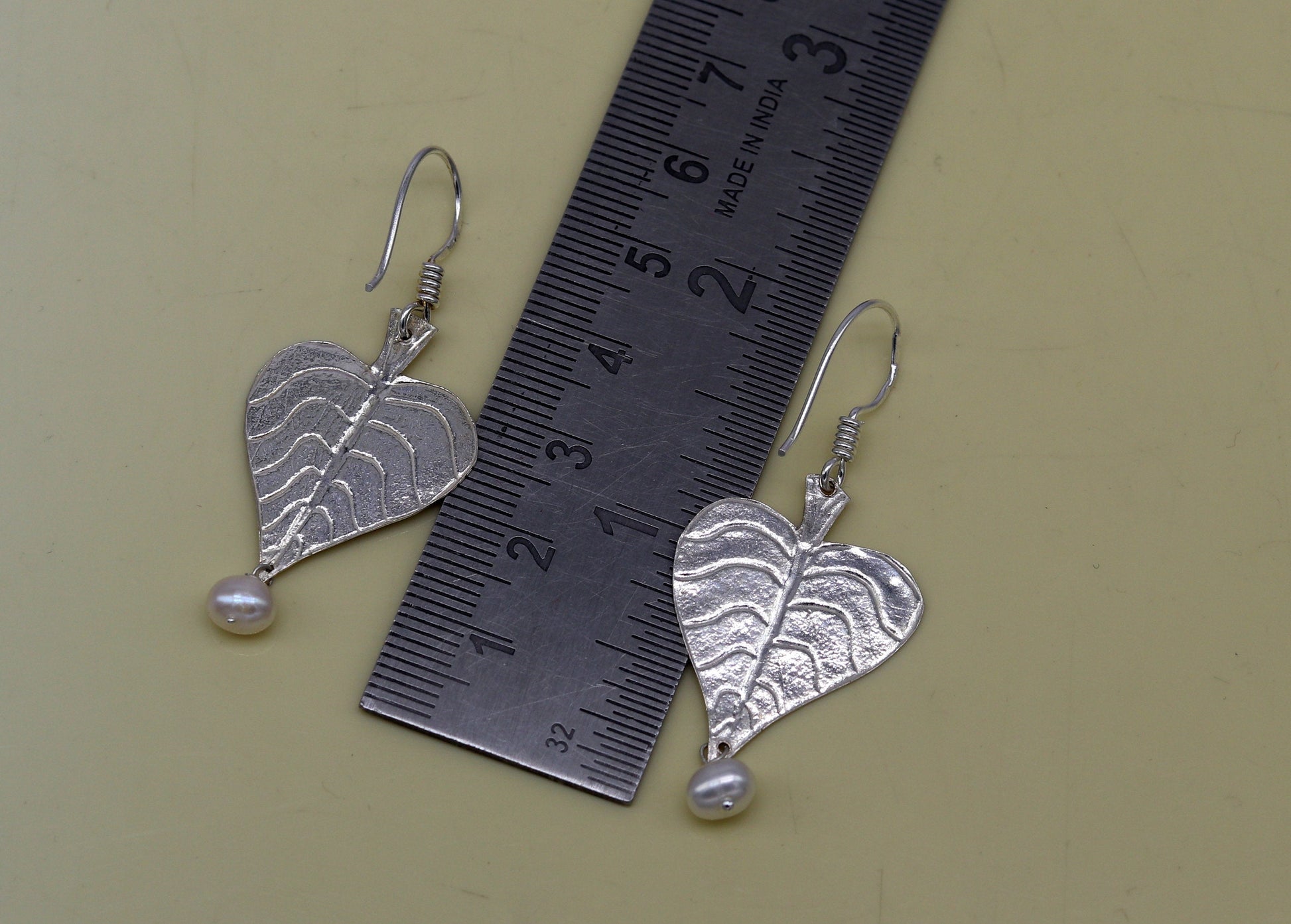 Sterling silver handmade peepal tree leaf earring with a hanging pearl, featuring customized hoop design from Tribal Ornaments.