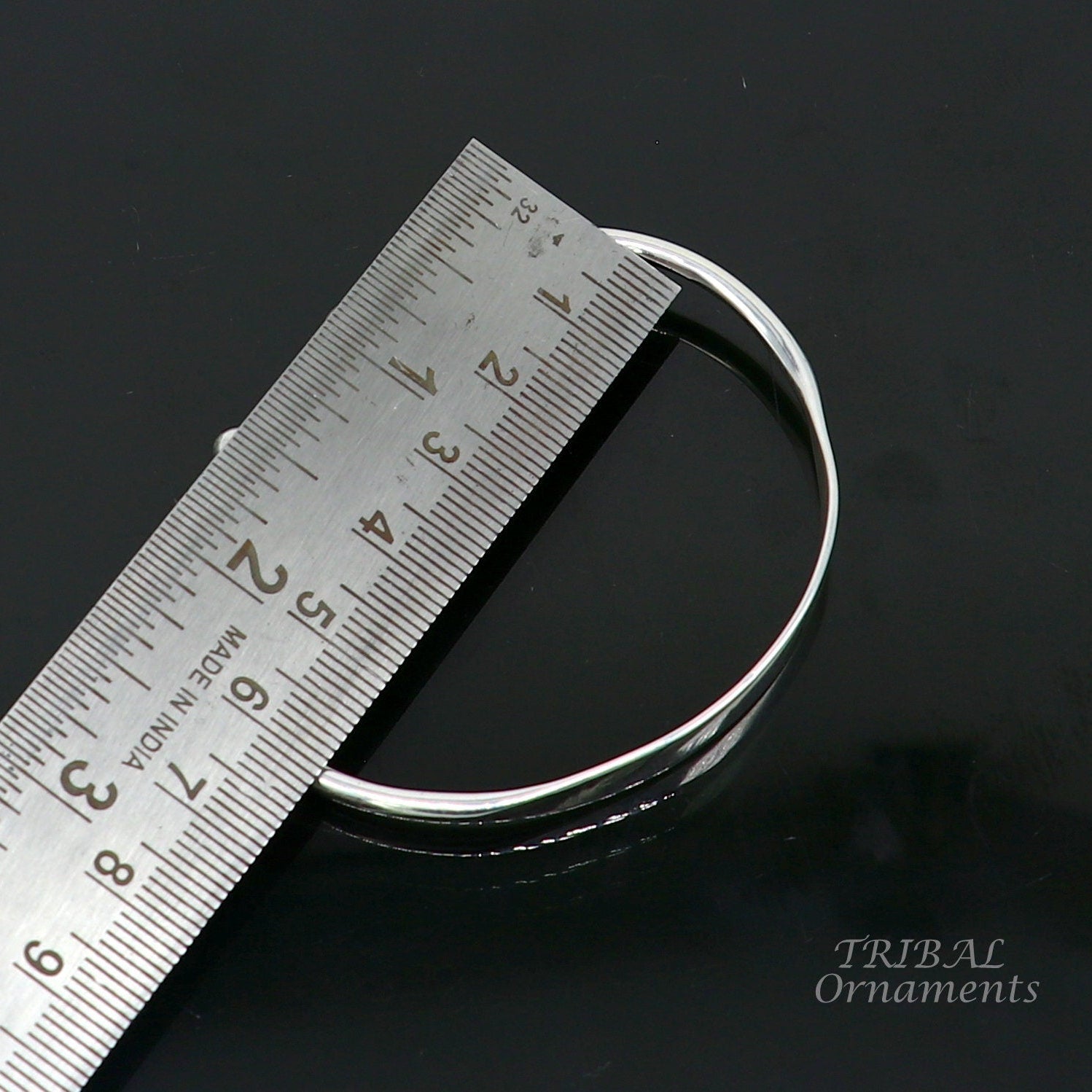 Sterling silver handmade bangle bracelet with a shiny plain design, stylish cuff style, perfect for gifting.