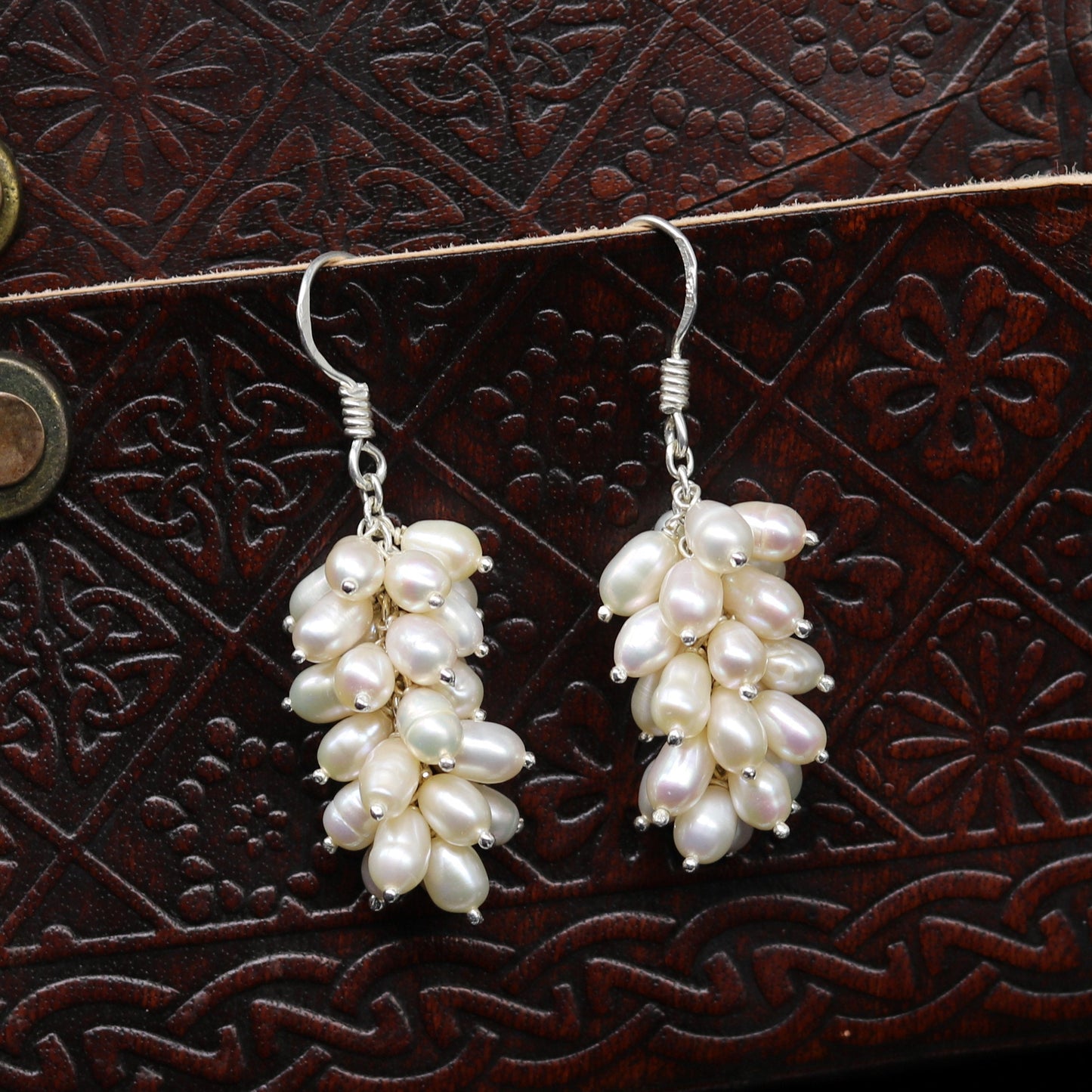 Sterling silver hoops earrings with elegant pearl accents by TRIBAL ORNAMENTS, showcasing shiny silver hoops and lustrous pearls.