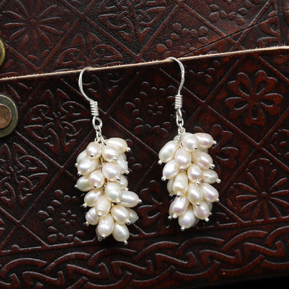 Sterling silver hoops earrings with elegant pearl accents by TRIBAL ORNAMENTS, showcasing shiny silver hoops and lustrous pearls.