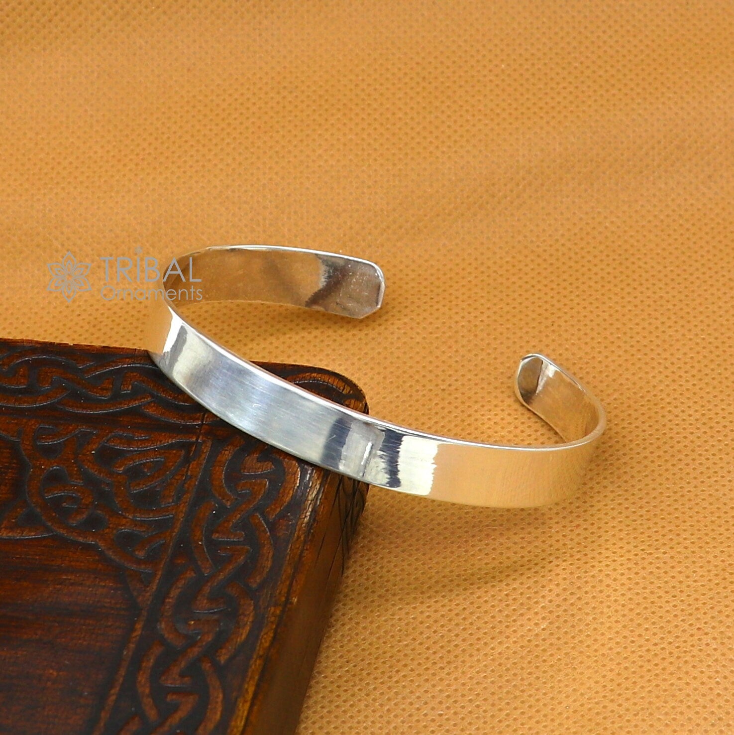 Sterling silver cuff bracelet by Tribal Ornaments, plain design for men and women, showcasing a smooth, polished silver bangle style.