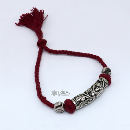 Sterling silver modern charm bracelet with intricate tribal designs, adjustable for bridal or ethnic jewelry occasions.