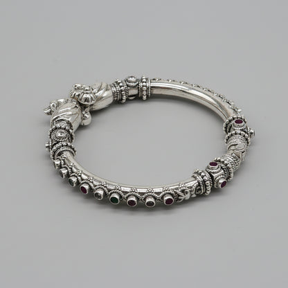 Sterling silver peacock design bangle bracelet with cubic zircon stones by TRIBAL ORNAMENTS, showcasing intricate feather details.