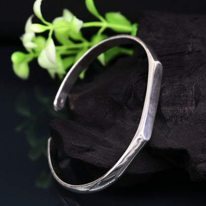 Sterling silver bangle bracelet from TRIBAL ORNAMENTS, shiny and adjustable, unisex cuff design for personalized gifting.