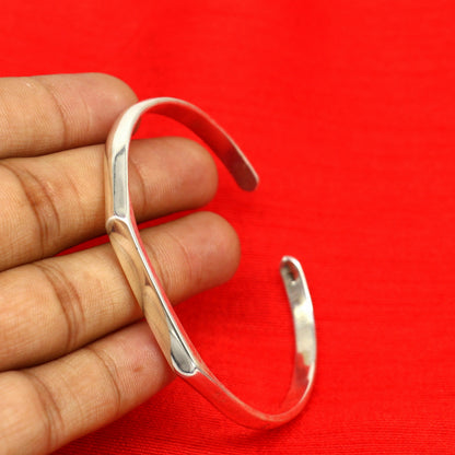 Sterling silver bangle bracelet by Tribal Ornaments, shiny and adjustable unisex cuff with personalized design.