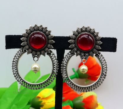 Sterling silver tribal earrings with handcrafted red glossy stone studs, showcasing traditional ethnic style and intricate design.