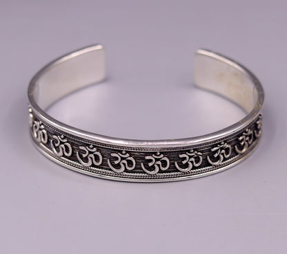 Stylish handcrafted 925 sterling silver 'AUM' mantra cuff bangle bracelet, adjustable unisex jewelry with ethnic design.