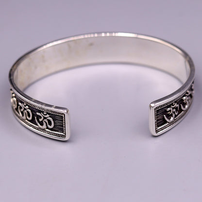 Sterling silver 'AUM' mantra cuff bracelet by TRIBAL ORNAMENTS, handcrafted adjustable unisex jewelry with ethnic design.