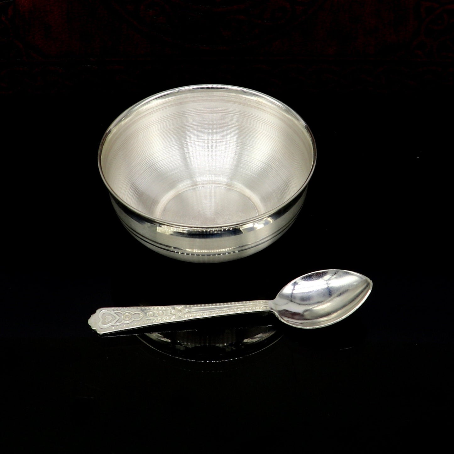 Handmade 999 pure fine silver utensils and baby bowl set by TRIBAL ORNAMENTS, including silver vessels and puja accessories.