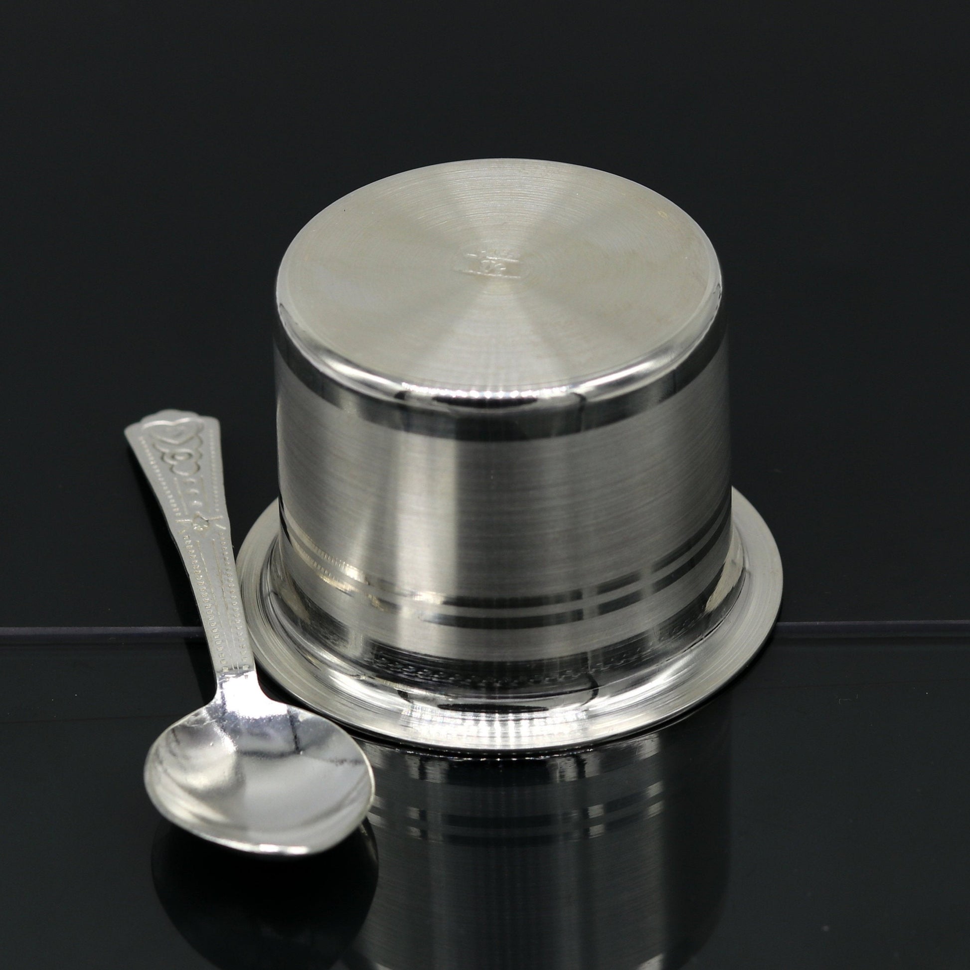 Handmade 999 pure silver baby feeding set with bowl and spoon from TRIBAL ORNAMENTS, featuring traditional silver vessels and utensils.