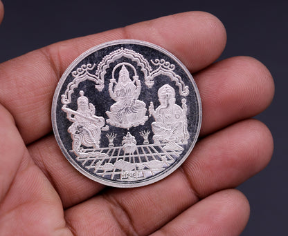 999 solid silver Indian idol coin featuring Lord Ganesha, Laxmi, and Saraswati print, 20 grams, collectible and ideal for gifting.
