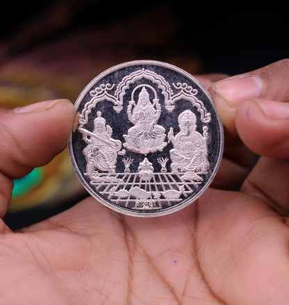 999 solid silver Indian idol coin featuring Lord Ganesha, Laxmi, and Saraswati print, 20 grams, collectible and ideal for gifting.