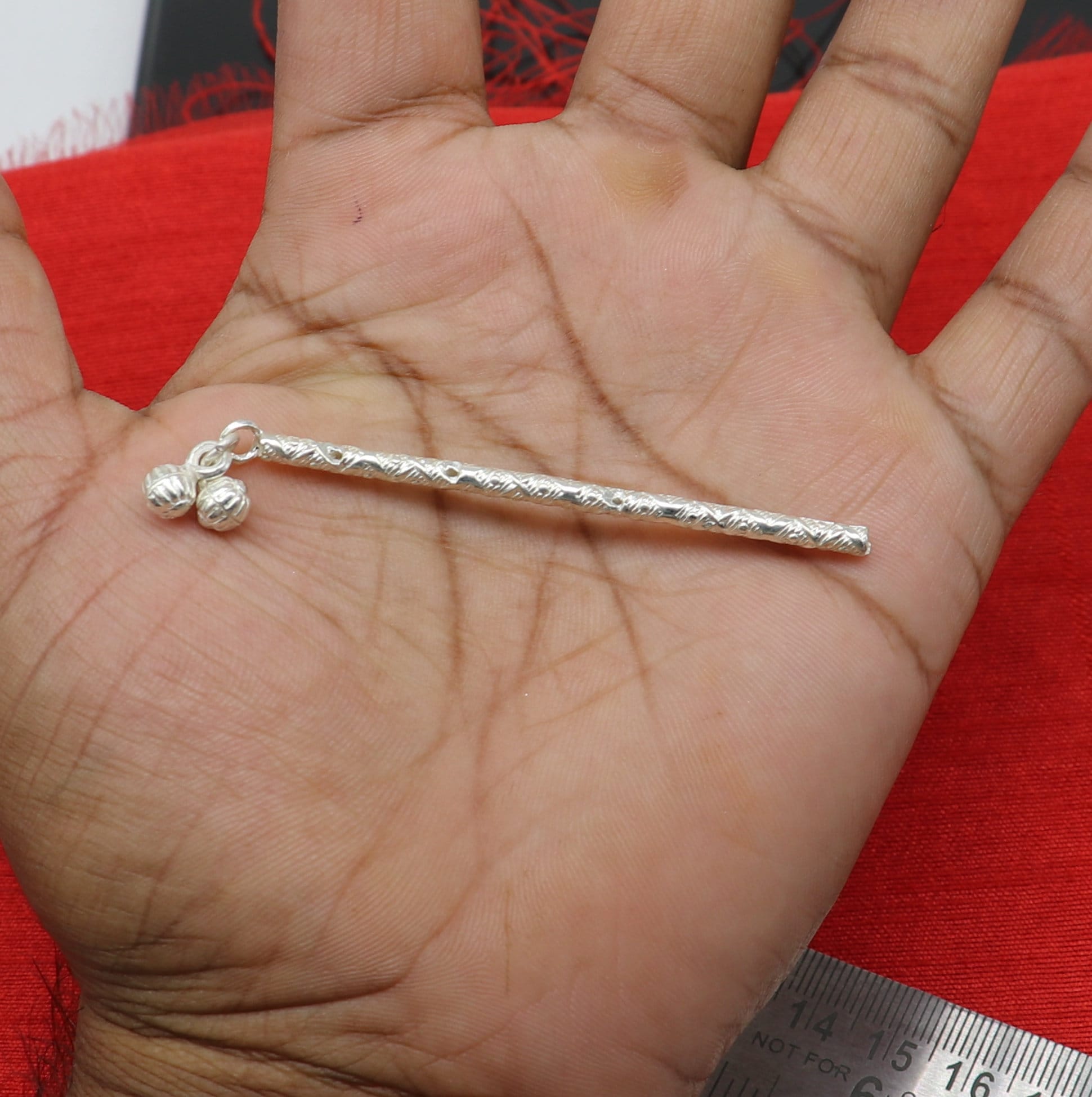 Handmade sterling silver Krishna flute idol with detailed traditional design, perfect for puja or decorative display.