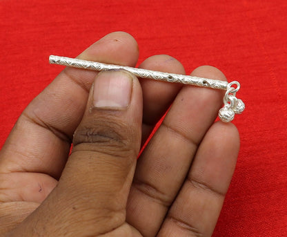 Handmade sterling silver Krishna flute idol with intricate design, featuring a silver bansuri and laddu Gopala details for puja art.