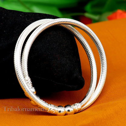 Sterling silver bangle bracelet with tribal design by TRIBAL ORNAMENTS, featuring customized patterns and traditional jewelry details.