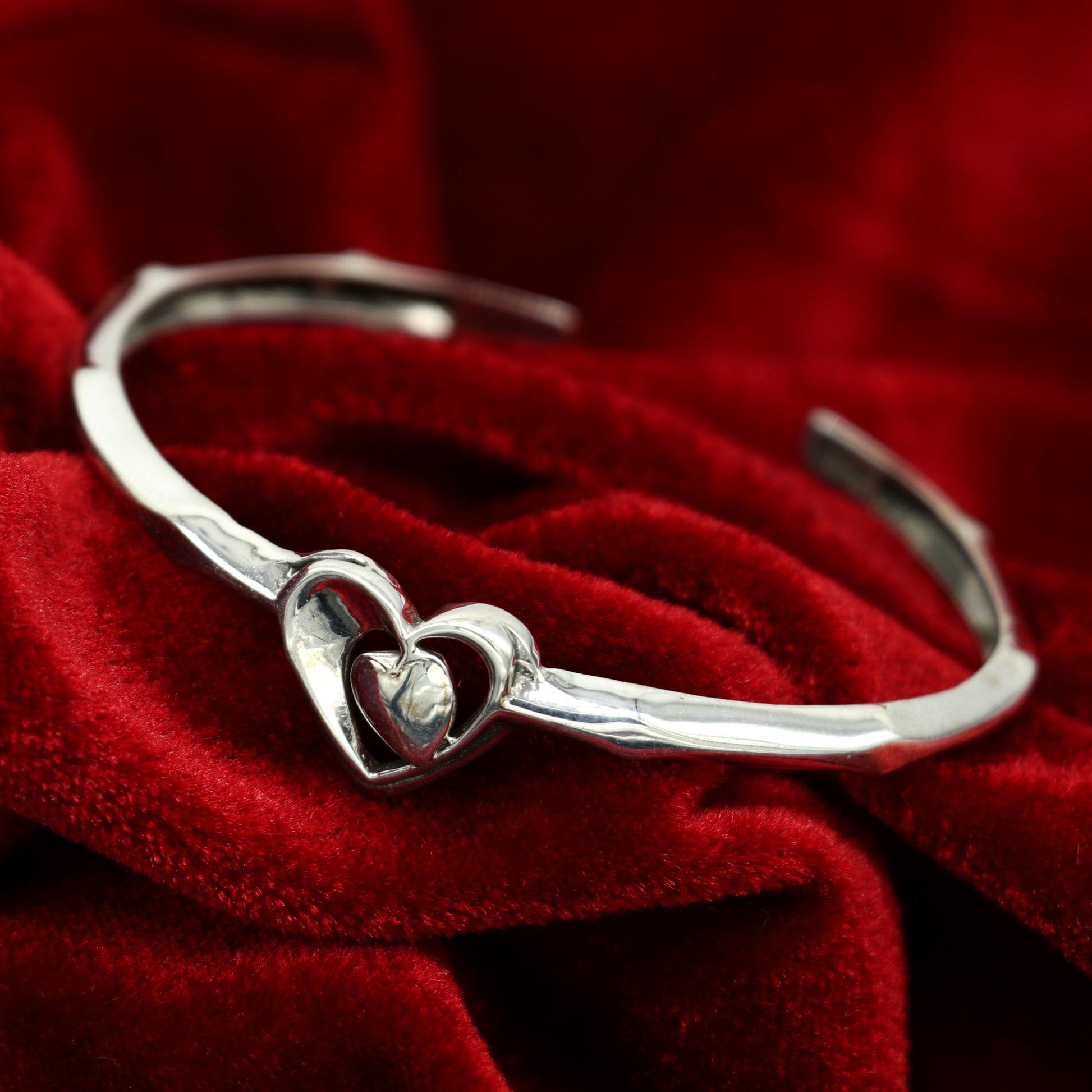 Sterling silver heart design bangle cuff bracelet by Tribal Ornaments, adjustable handmade jewelry with intricate heart details.