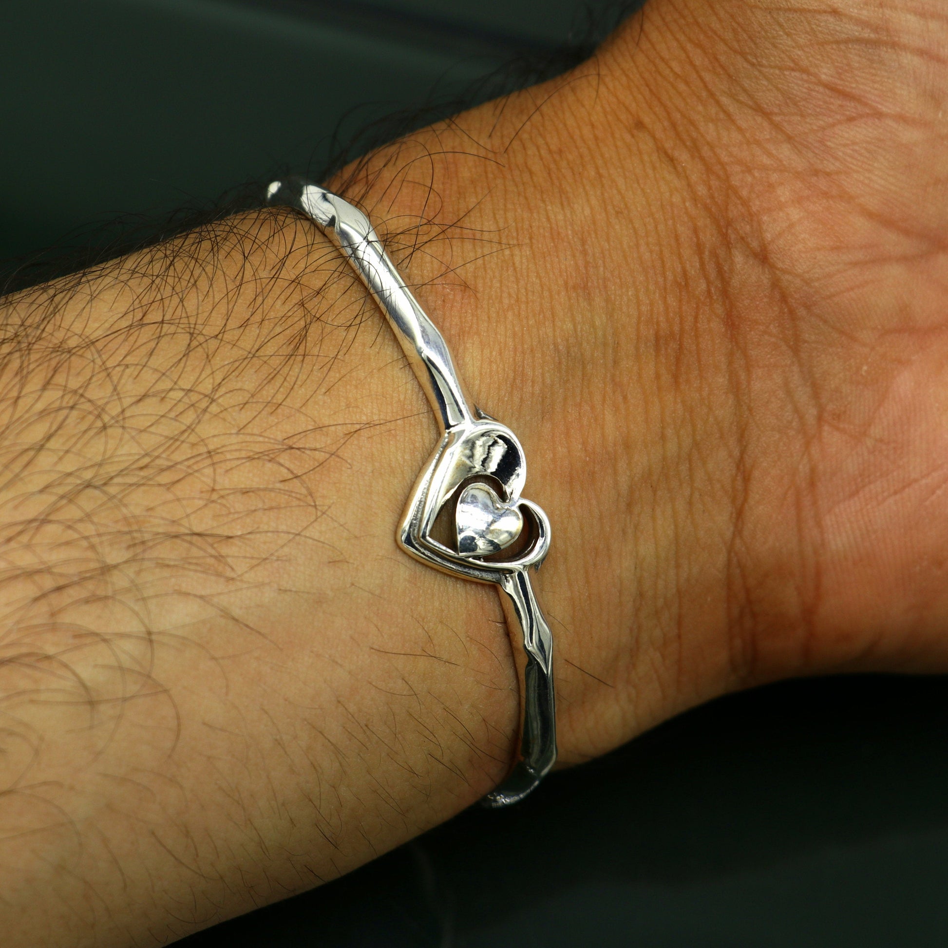 Sterling silver heart design cuff bracelet by TRIBAL ORNAMENTS, adjustable handmade jewelry with elegant silver craftsmanship.