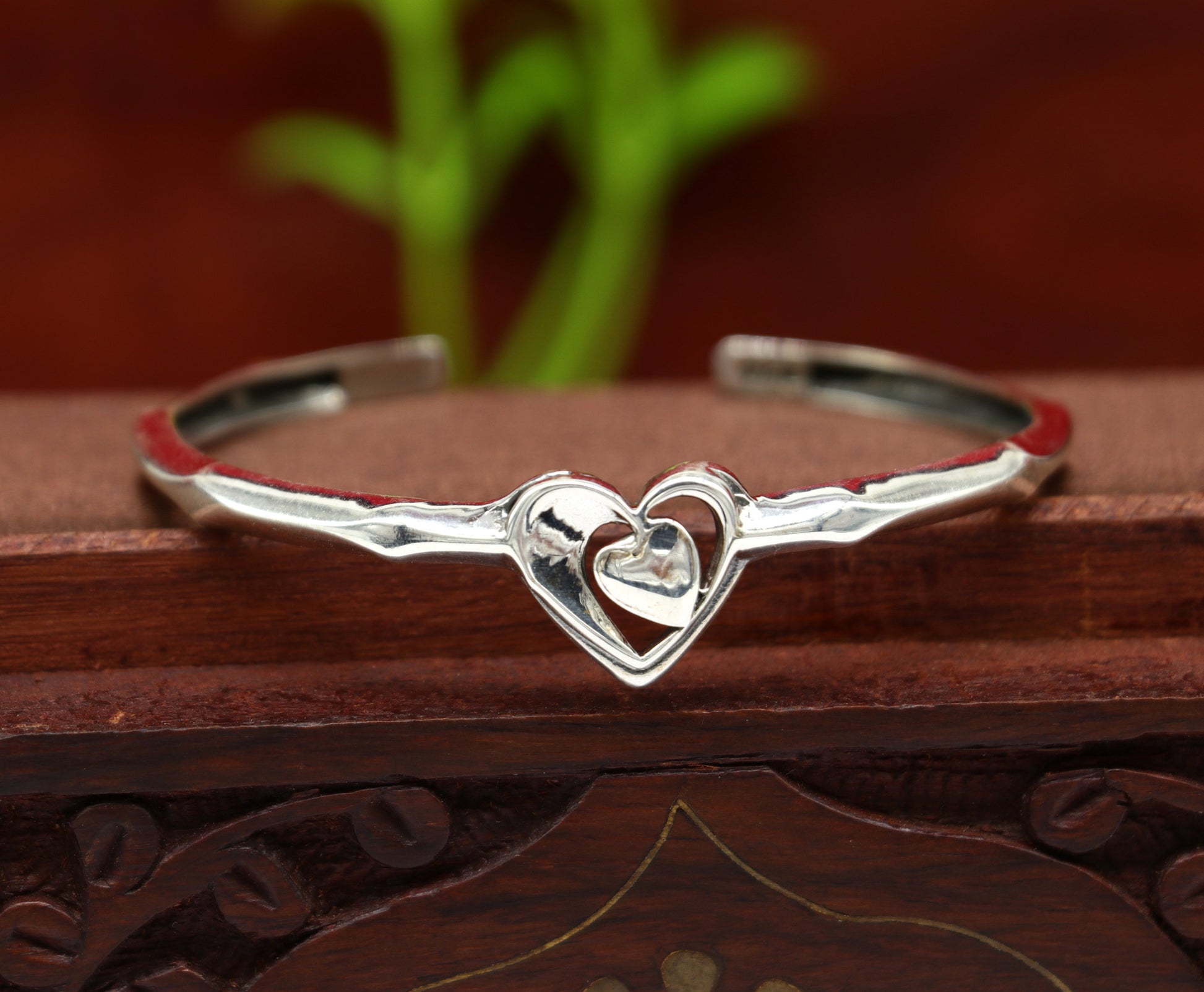 Sterling silver heart design bangle cuff bracelet from TRIBAL ORNAMENTS, with adjustable fit and handcrafted intricate details.