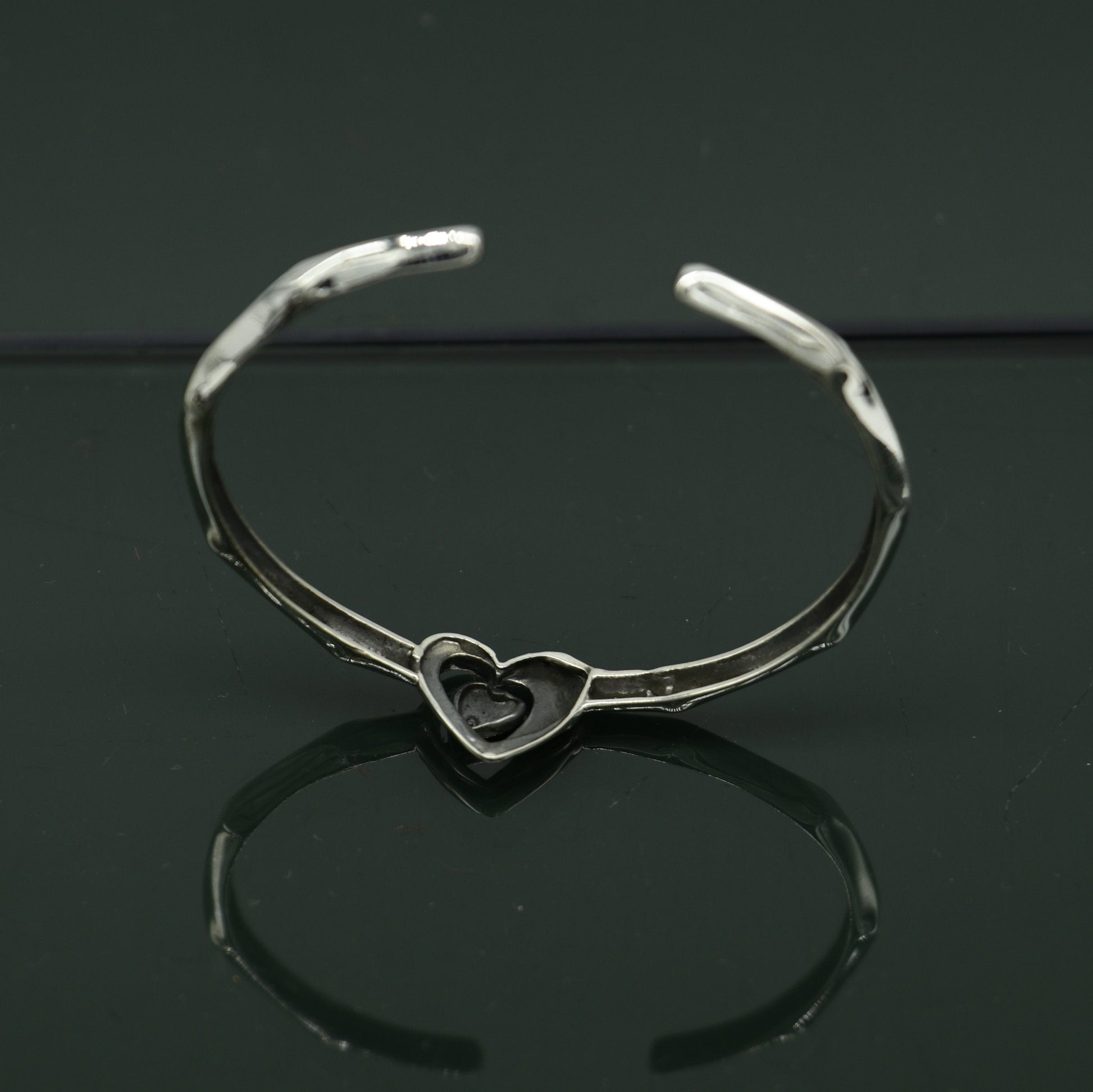 Sterling silver heart design bangle cuff bracelet by Tribal Ornaments, adjustable handmade jewelry with intricate heart details.
