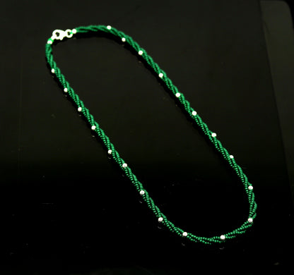 Custom made triple strand necklace with green semiprecious beads and silver accents, designed with a galaxy-inspired arrangement.