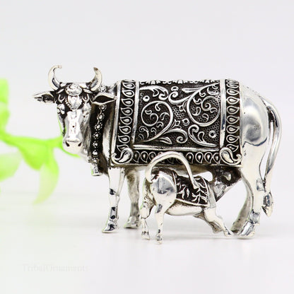 Silver Kamdhenu cow and calf sculpture with vintage Nakshi work, depicting a divine worshipping cow in detailed sterling silver art.