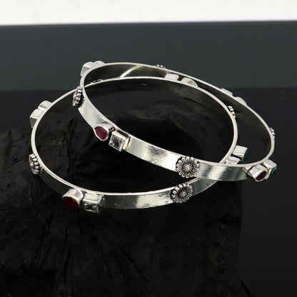 Sterling silver tribal bangle bracelet with green and red stones, featuring a plain design and handmade craftsmanship.