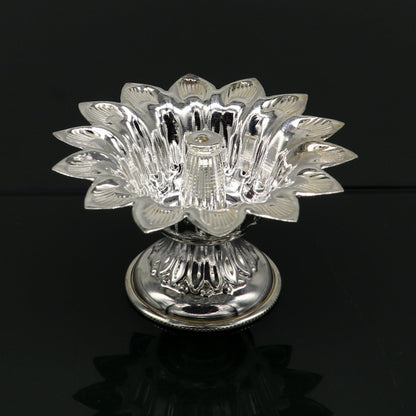 Handmade silver flower-shaped oil lamp, temple utensils, and decorative silver diya by TRIBAL ORNAMENTS.