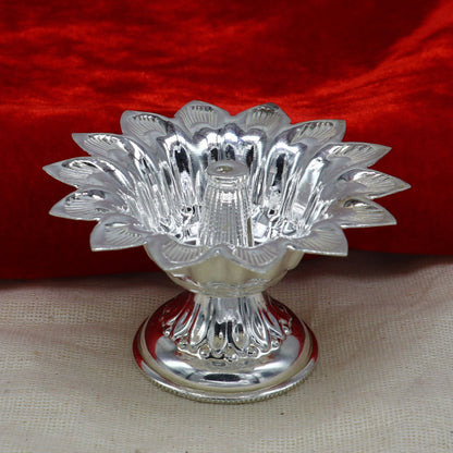 Handmade silver flower-shaped oil lamp by TRIBAL ORNAMENTS, decorative silver diya and temple utensils for spiritual decor.