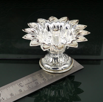 Handmade silver flower-shaped oil lamp by TRIBAL ORNAMENTS, featuring temple utensils and decorative silver diya vessels.