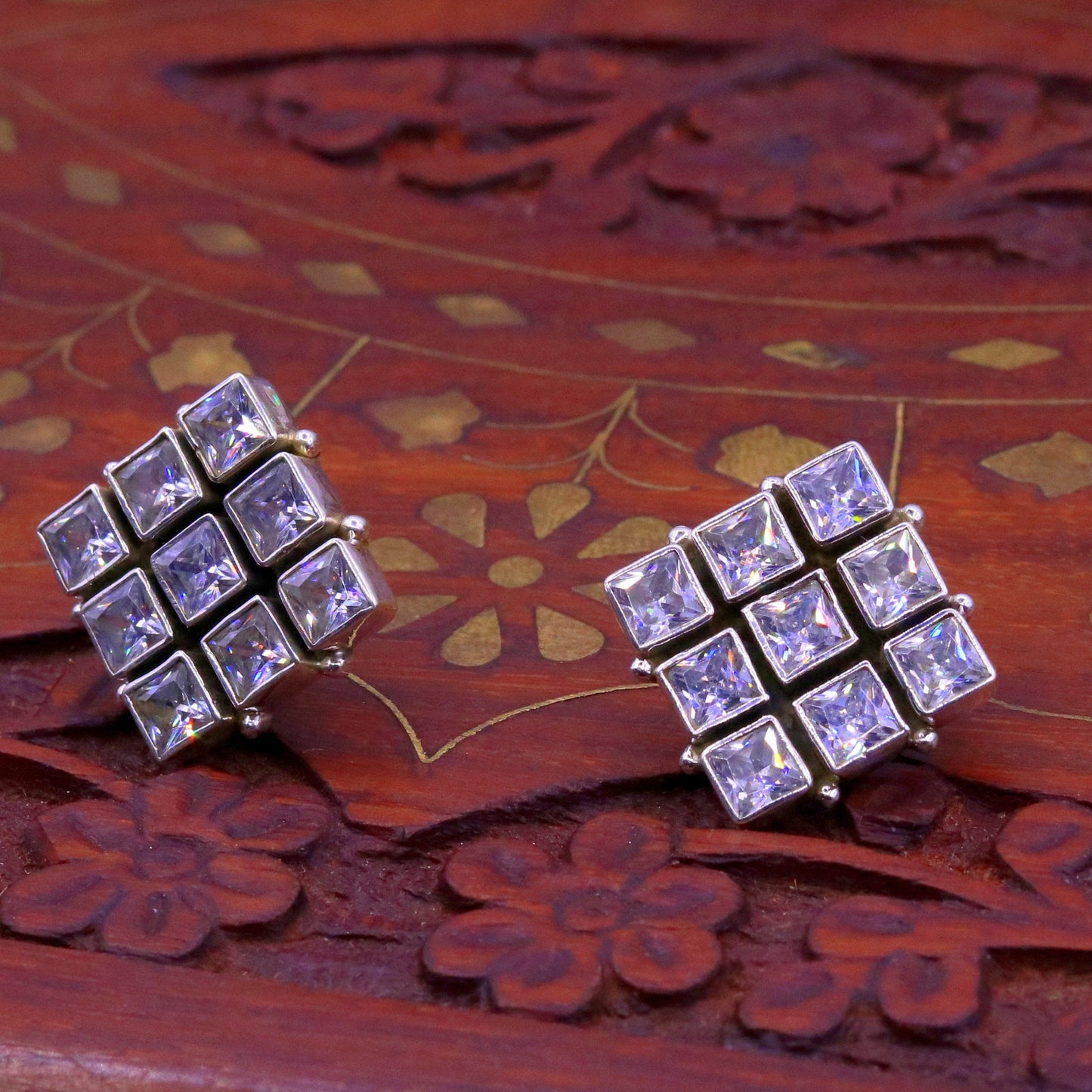 Handmade sterling silver cubic zirconia stud earring with a matching pendant, showcasing intricate tribal design and sparkling stones.
