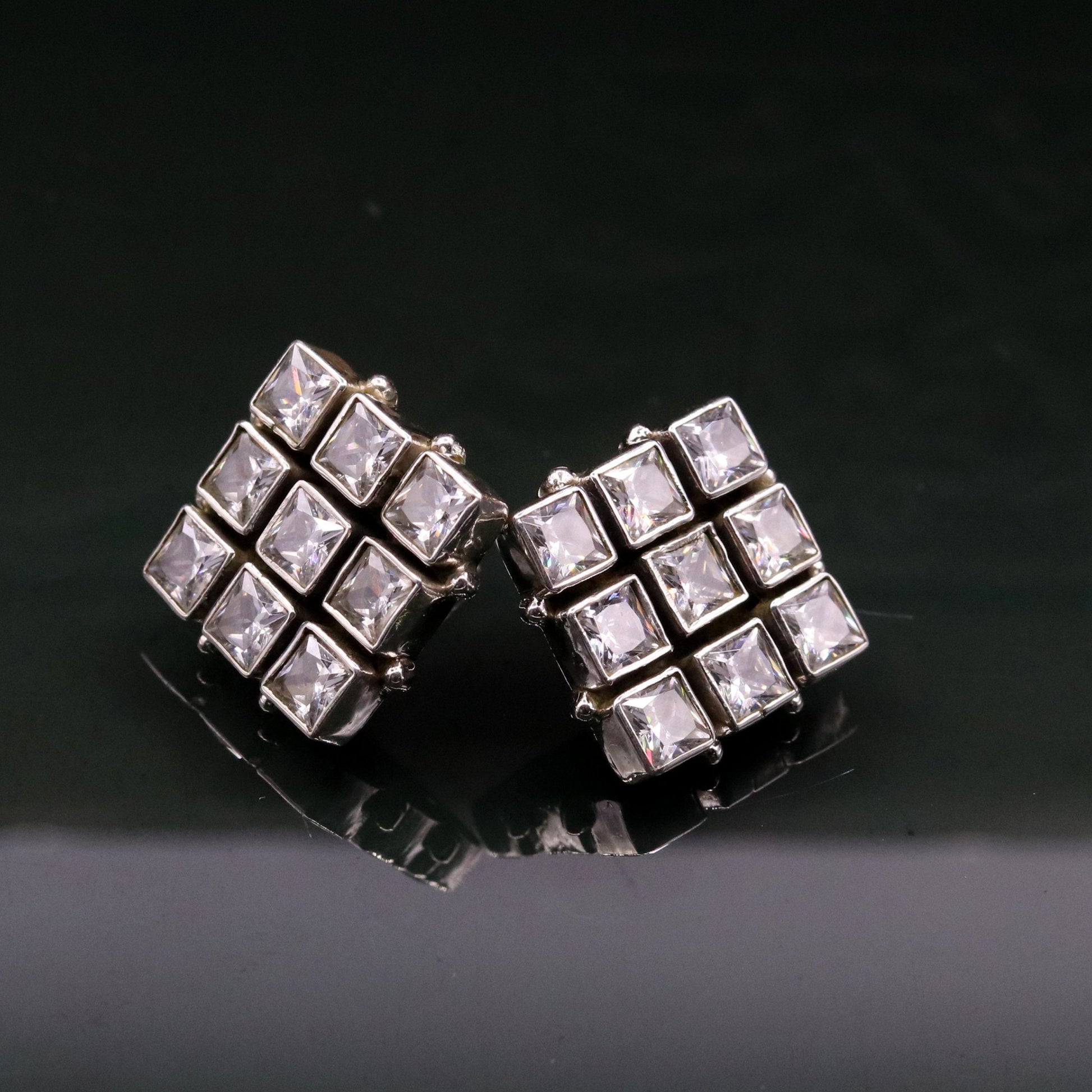 Handmade sterling silver stud earring with cubic zirconia and a pendant, showcasing intricate tribal design and elegant craftsmanship.