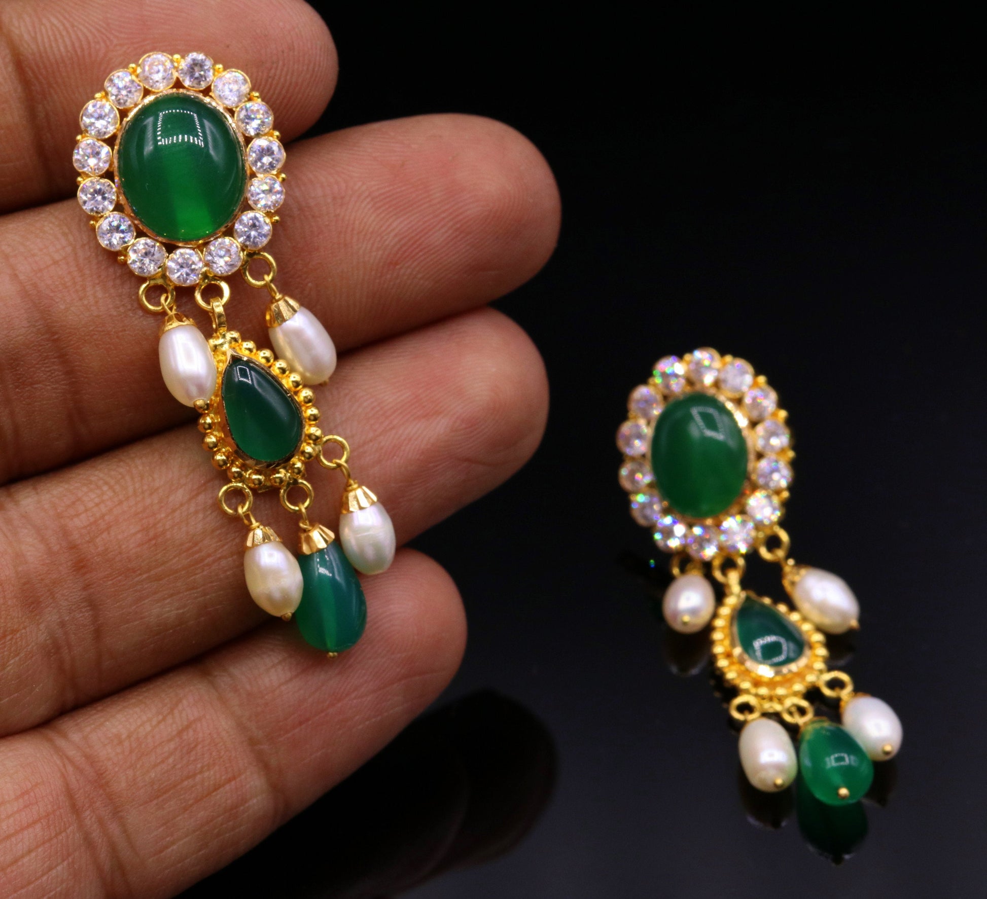 Handmade Indian tribal earrings with green stones and 22k yellow gold in traditional Rajasthan style, featuring dangling design.