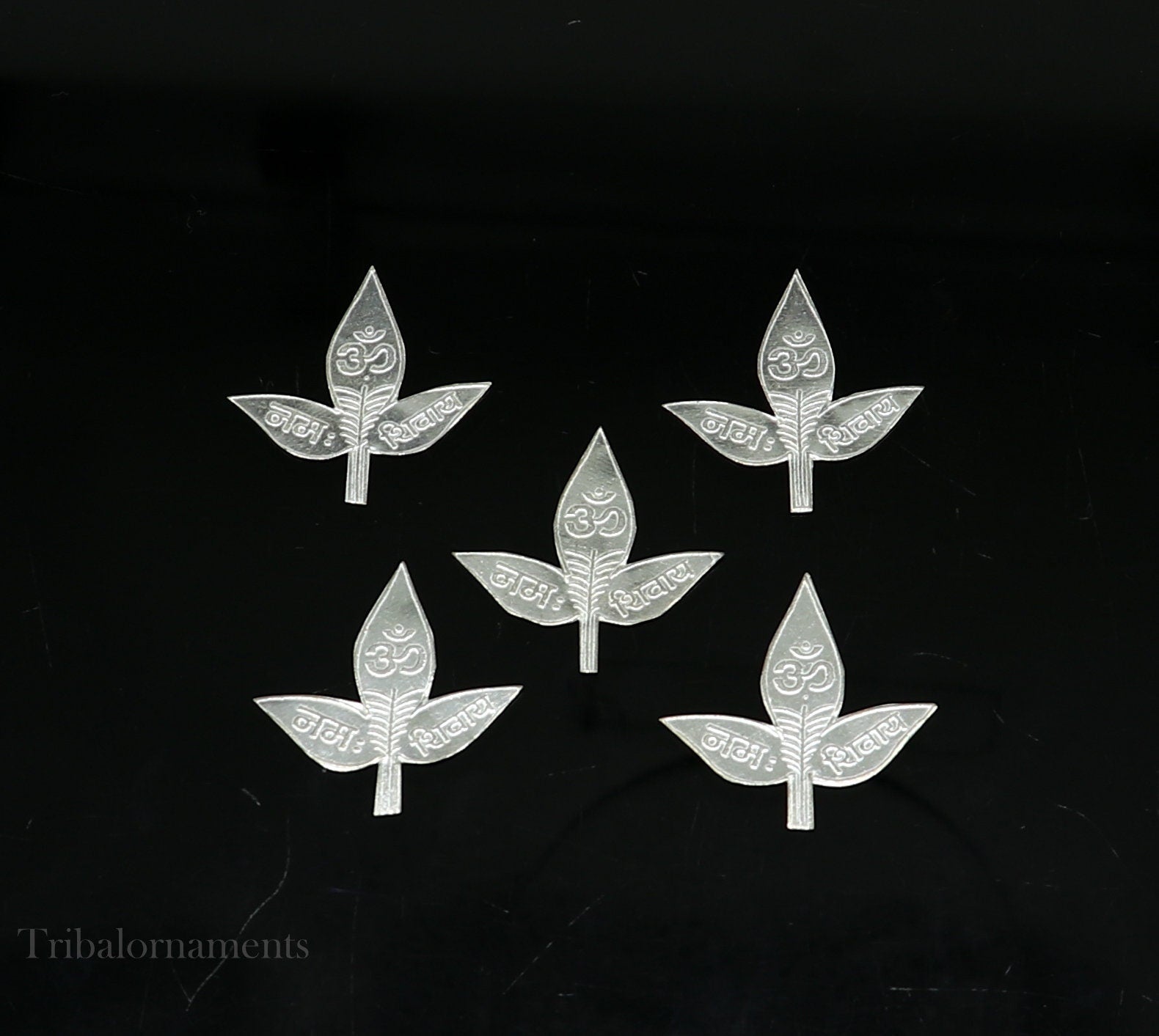 Set of 5 handmade solid silver Belva Patra leaves for Shiva worship, featuring intricate designs and Shiva mantras on each leaf.