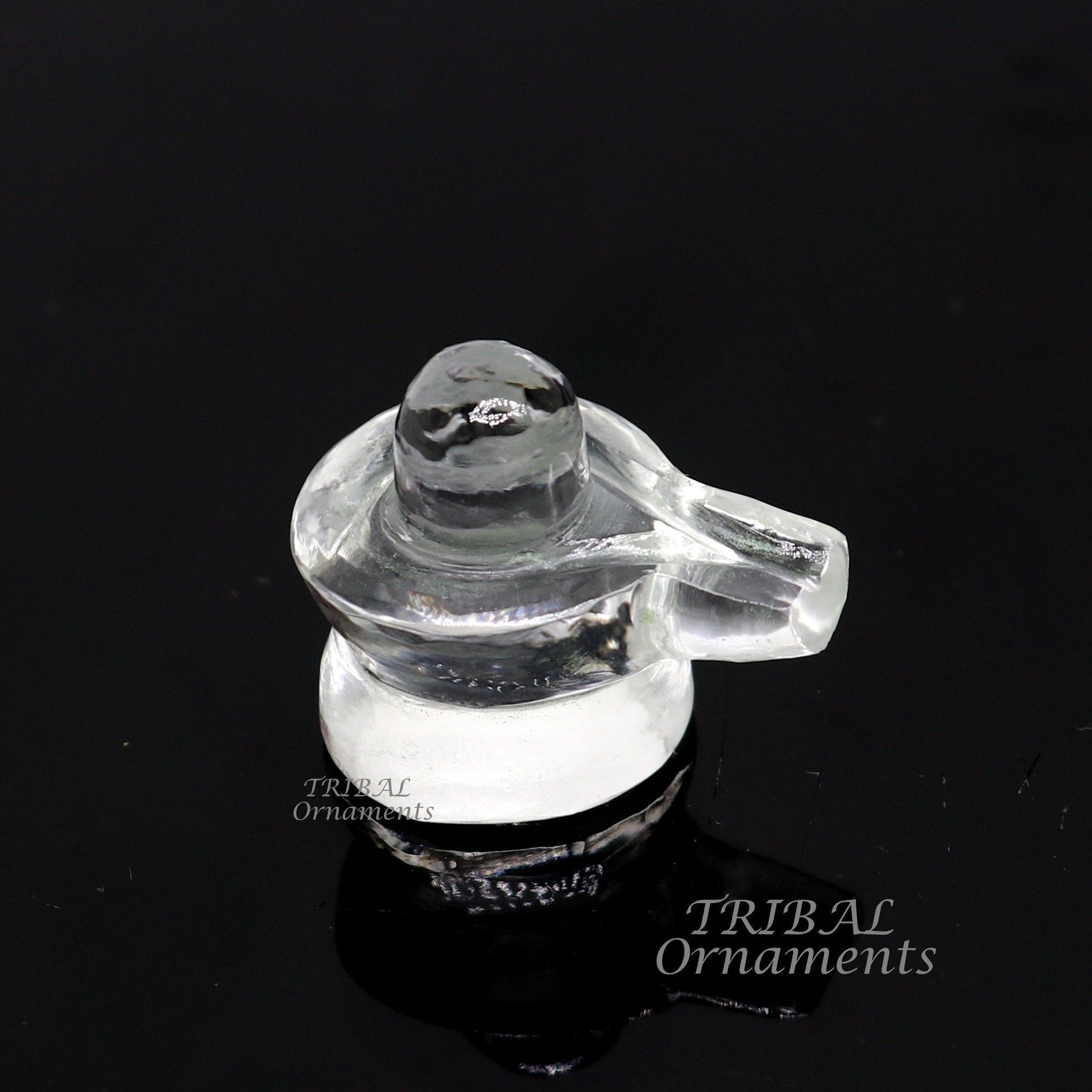 Natural sphatik crystal Shiva Lingam statue from TRIBAL ORNAMENTS, used for wealth and prosperity puja, detailed stone carving.