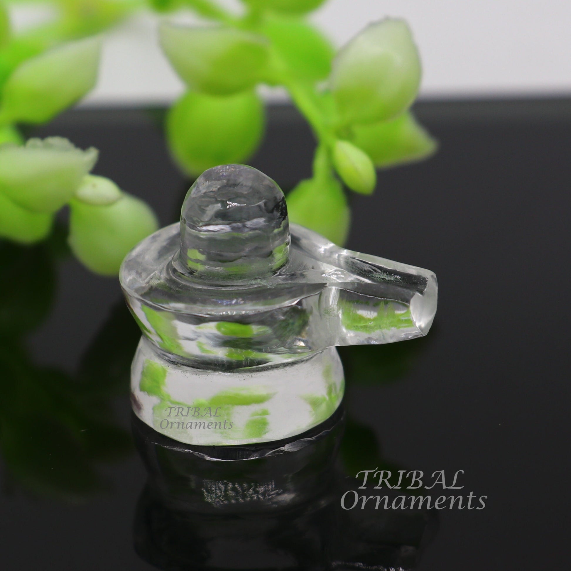 Natural Sphatik crystal Shiva Lingam statue by TRIBAL ORNAMENTS, used for wealth and prosperity puja rituals, detailed stone design.
