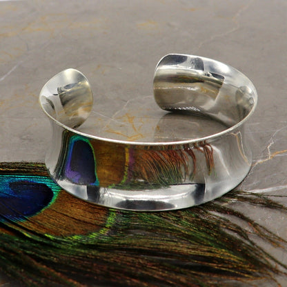 Bright shiny 925 sterling silver cuff bangle bracelet with a modern curved design, stylish and elegant jewelry by Tribal Ornaments.