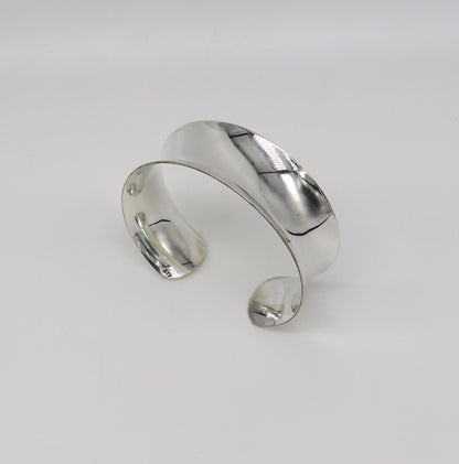 Bright shiny 925 sterling silver cuff bracelet with a modern trendy curved design, featuring an elegant Bollywood-inspired style.